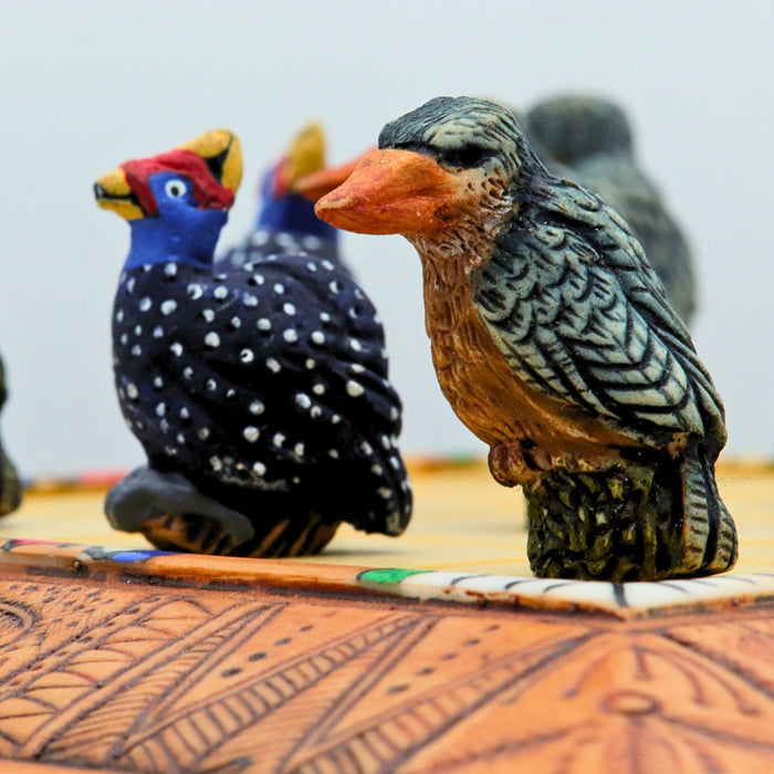 Close up of African Bird Noughts & Crosses resin game set with hand-painted birds showcasing Kingfisher & Guineafowl pieces