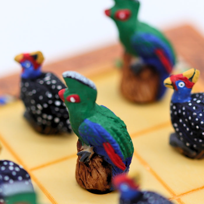 Close up of African Bird Noughts & Crosses resin game set with hand-painted birds showcasing Loerie & Guineafowl pieces