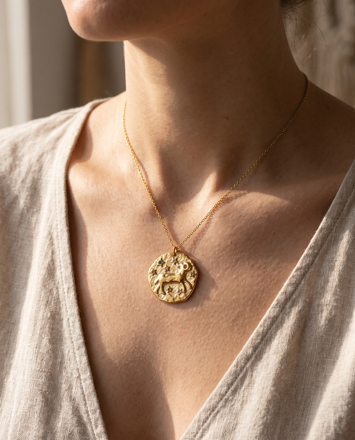 Aries zodiac pendant worn on a fine gold chain