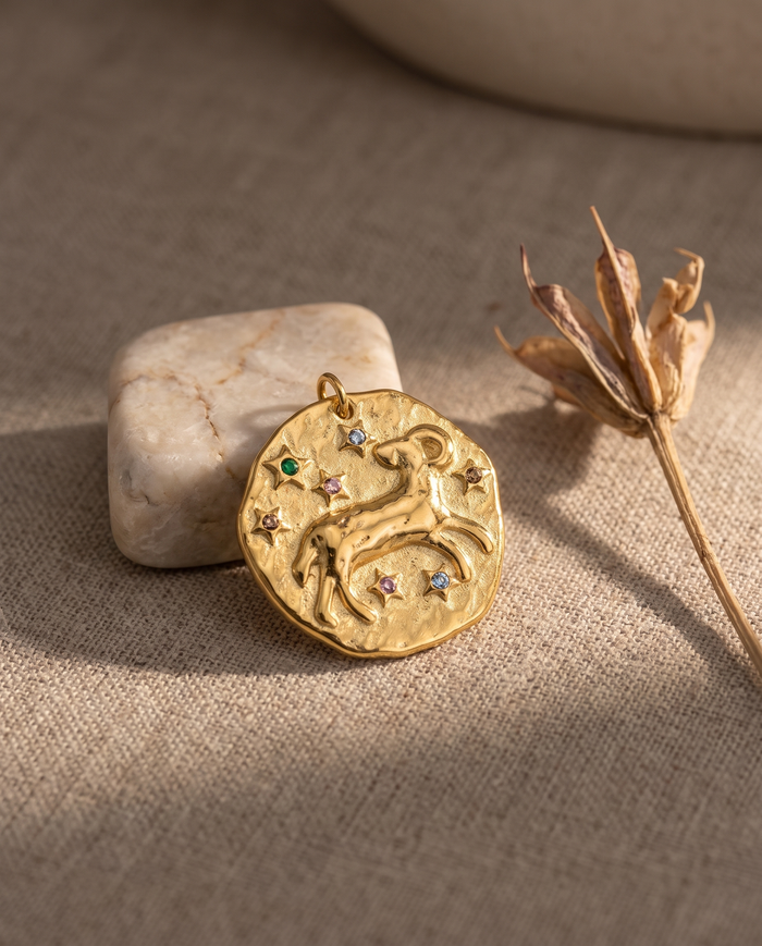 Aries zodiac pendant styled on linen with marble