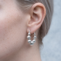 Close-up of the Aino silver bubble hoop earring worn on the ear