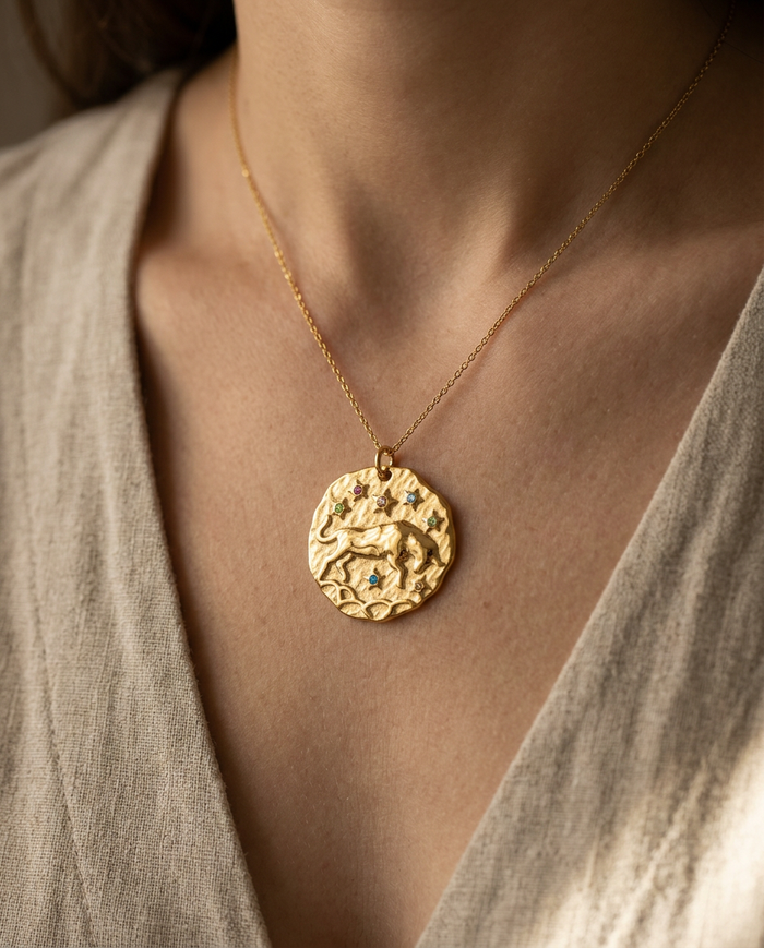 Taurus zodiac pendant worn on a fine gold chain