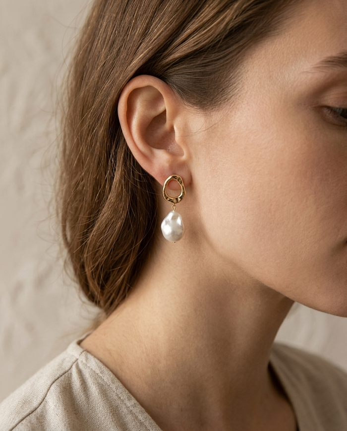 Geometric hoop earring with pearl drop worn on the ear