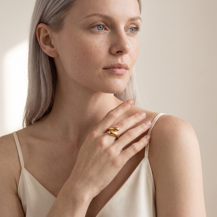 Model wearing the Ansa gold-plated sculptural hug ring on her index finger