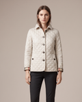 Astrid diamond-quilted jacket with contrast lining in off-white, editorial studio shot
