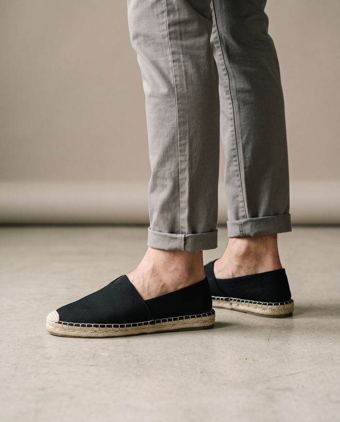 Black elegant espadrilles worn on model