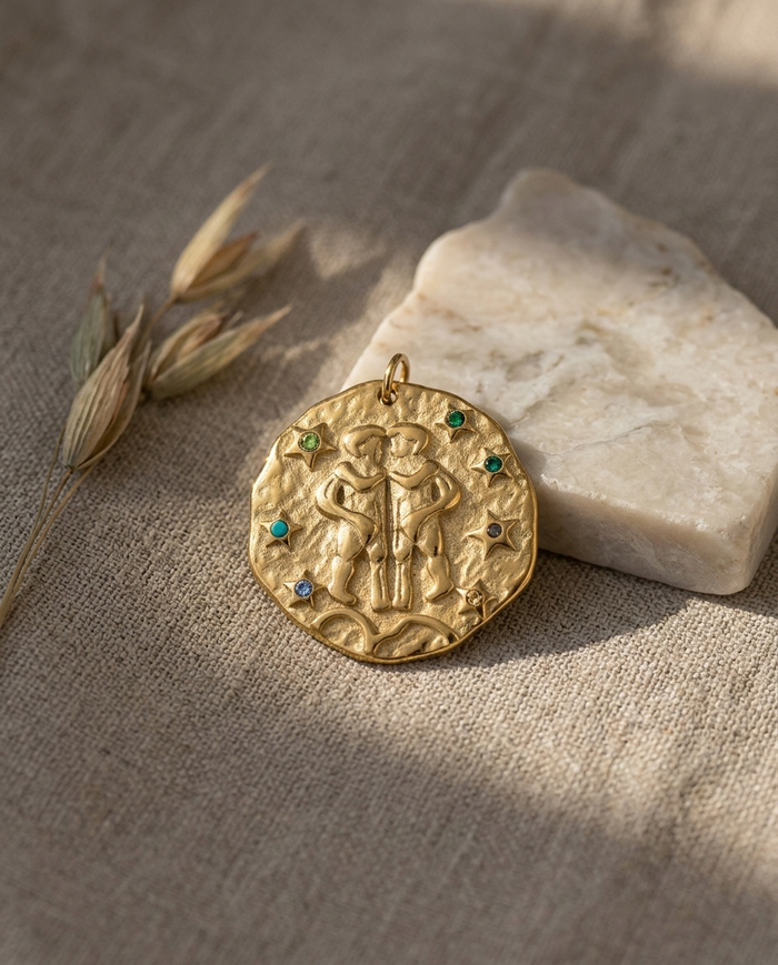Gemini zodiac pendant styled on linen with marble