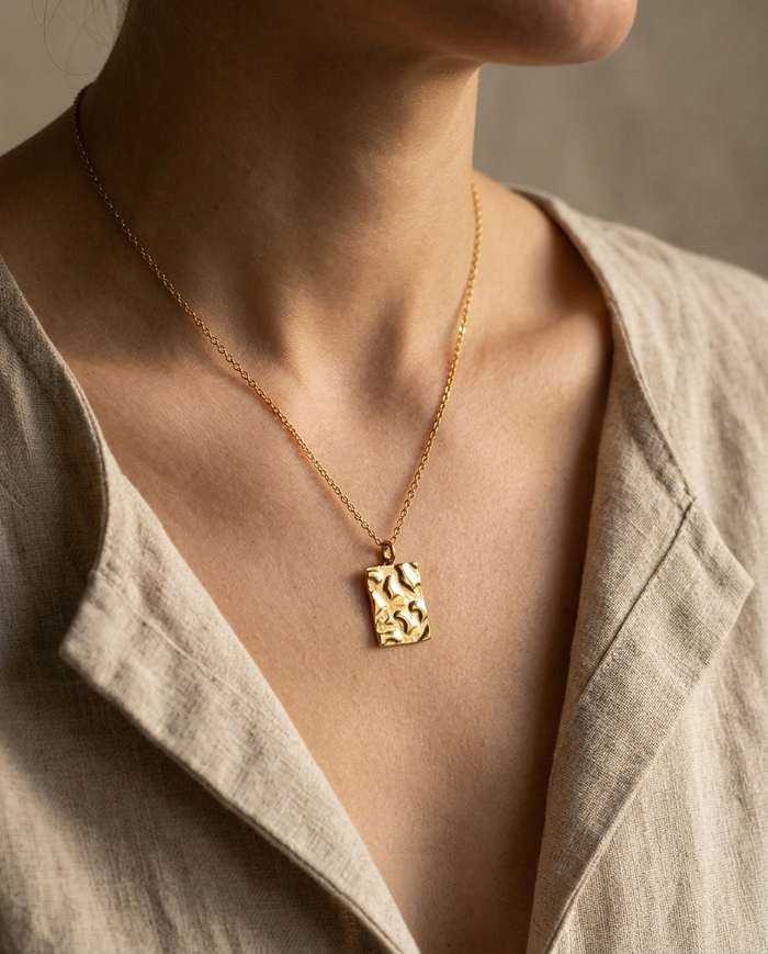 Square hammered disc necklace worn at the collarbone