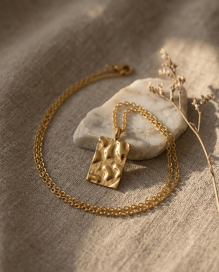 Square hammered disc necklace styled on linen with marble