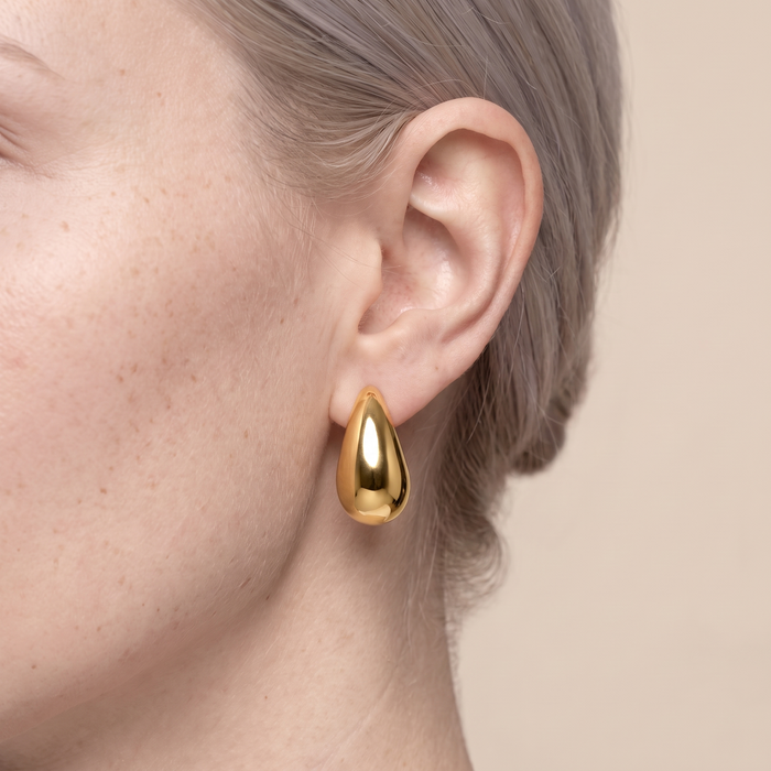 Close-up of the Enni gold-plated drop earring worn on the ear