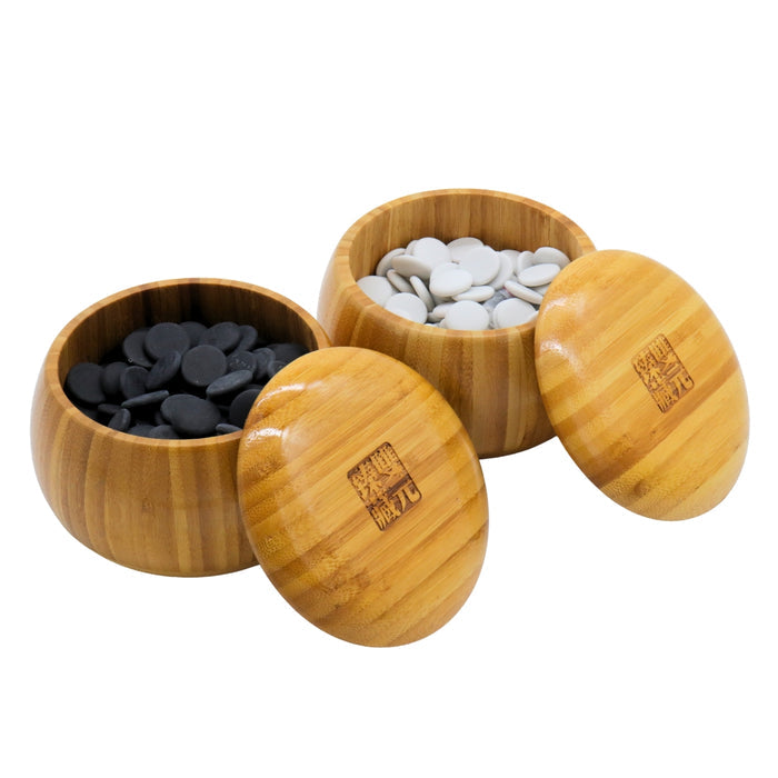Go Bowls & Stones Set with lids lifted off 2 bamboo bowls showing black and white ceramic go stones
