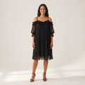 Woman wearing the Ilta black pleated chiffon dress with off-shoulder lace neckline, front view