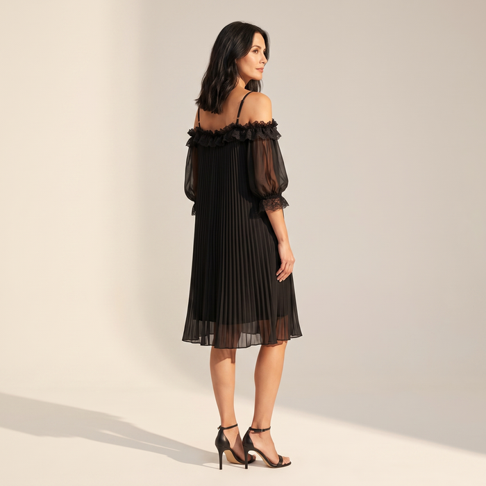 Ilta black pleated chiffon dress seen from the side, showing the A-line shape and sheer puff sleeve