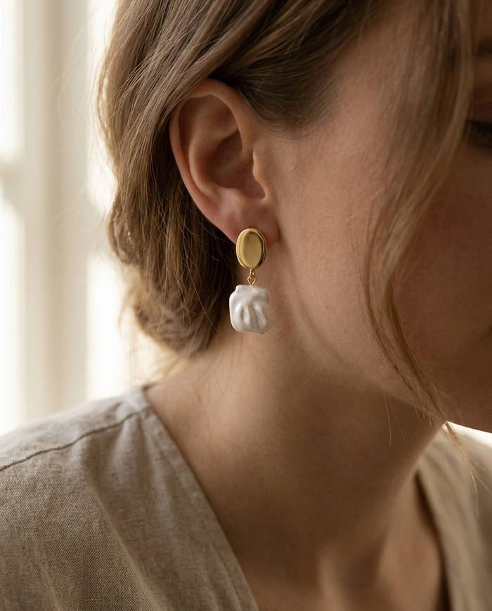 Gold-plated square pearl drop earring worn on the ear