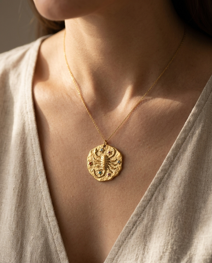Scorpio zodiac pendant worn on a fine gold chain