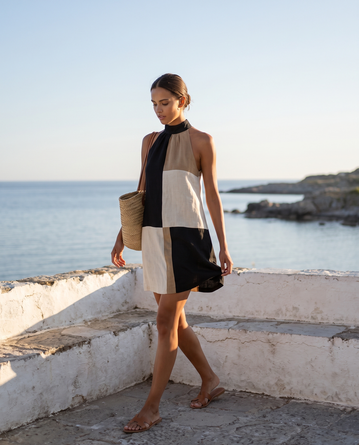 Nadia colour-block halter mini dress worn on a sunlit Nordic coastal terrace