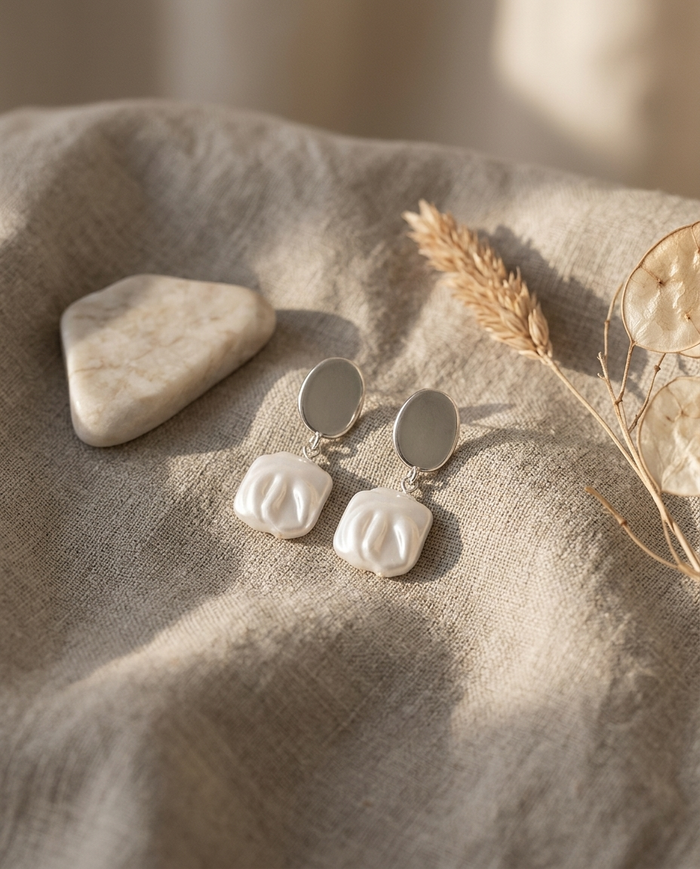Silver square pearl drop earrings styled on linen