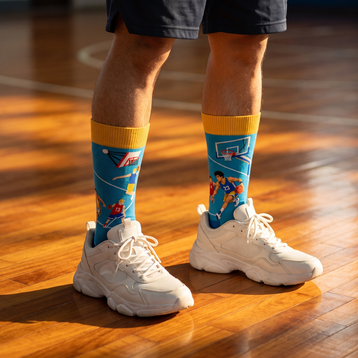 Legs in long jacquard sports socks and trainers on a wooden court floor