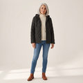 Woman wearing the Routa black diamond-quilted hooded jacket, front view