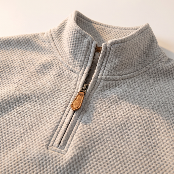 Close-up of the half-zip placket and leather-look pull tab on the waffle sweatshirt