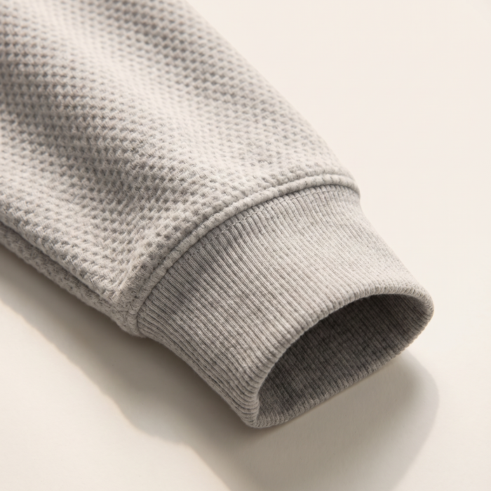 Sleeve detail of the waffle sweatshirt showing the ribbed cuff and waffle texture
